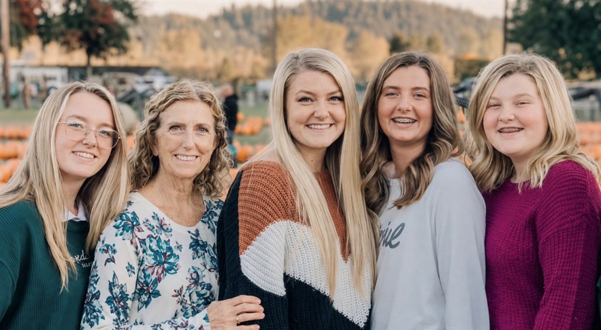 Grandma with her family smiling together at a pumpkin patch